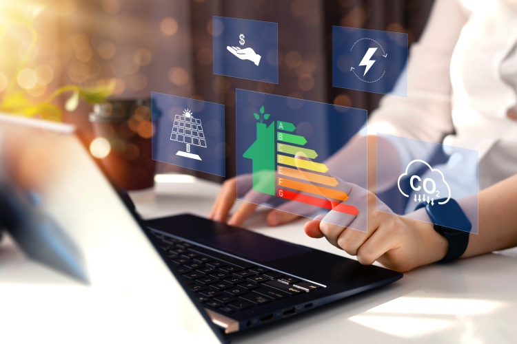 An open laptop with charts and graphs related to energy efficiency floating above the keyboard.